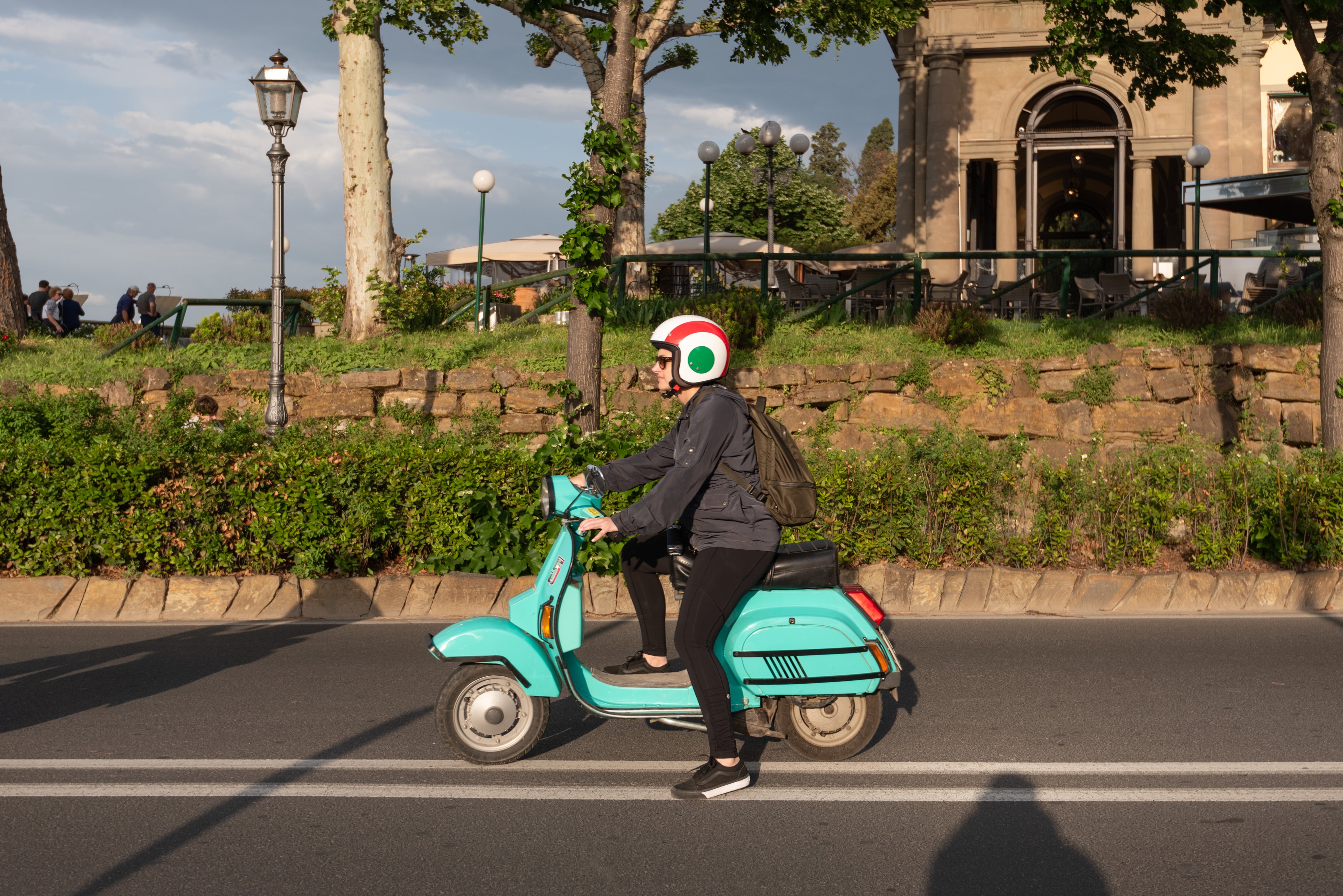a-woman-on-a-turquoise-moped-on-a-highway.jpg